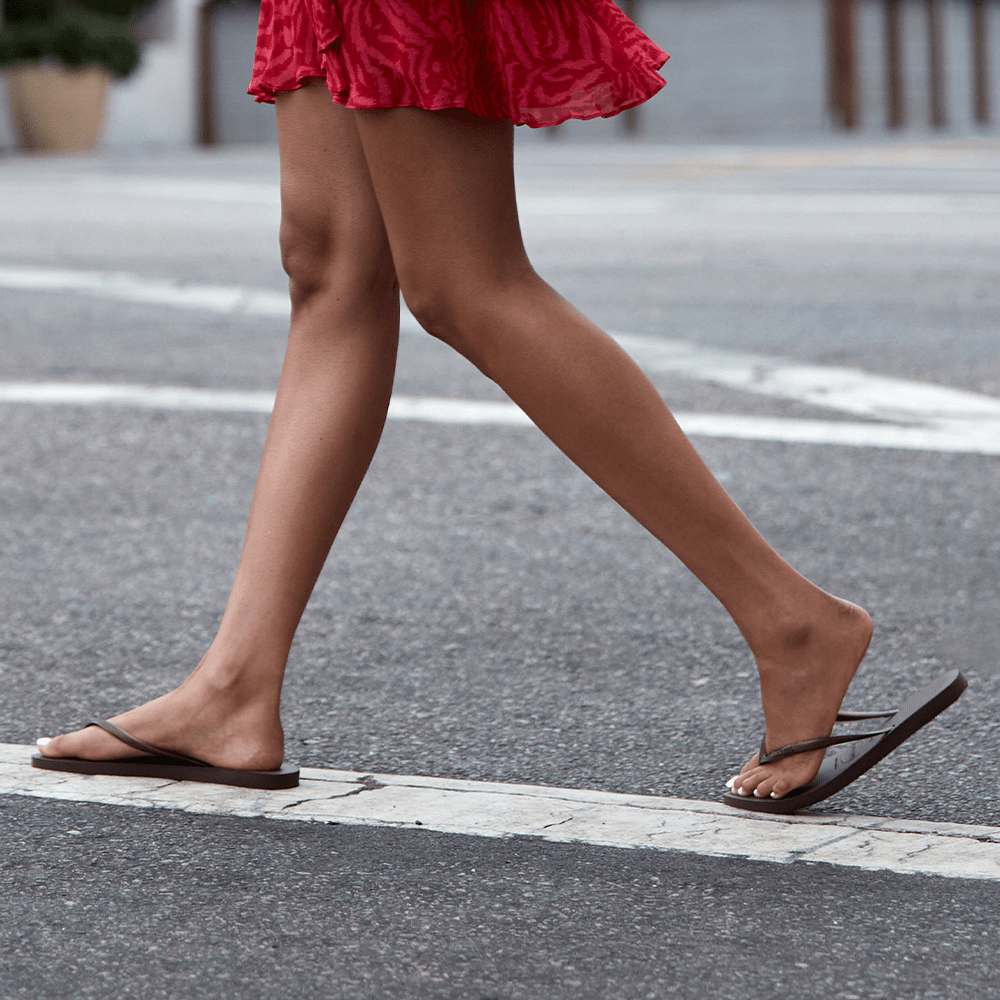 Women's brown flip flops with metallic brown straps lifestyle image