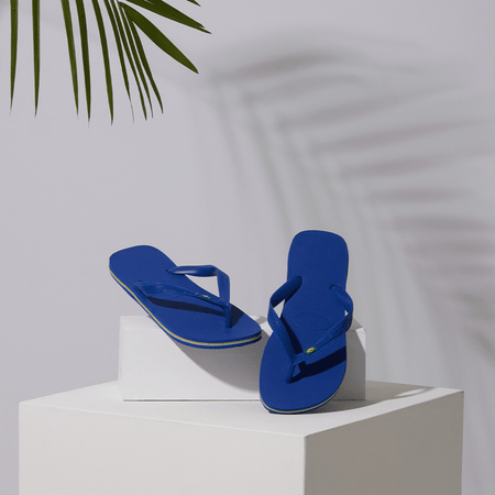 Women's cobalt blue flip flop with Brazil flag detail on the straps, lifestyle image