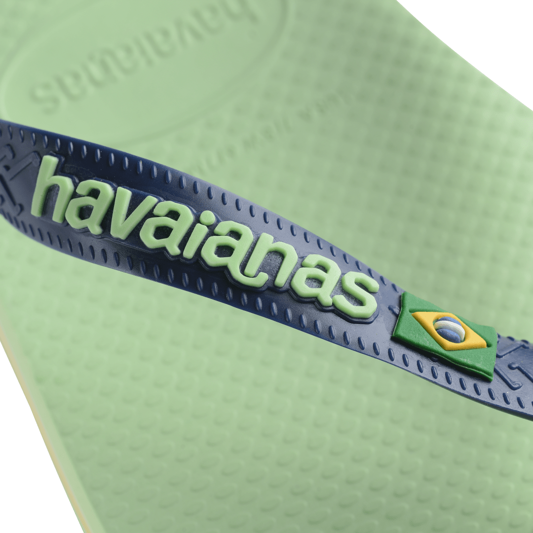 Women's light green flip flop with navy straps featuring Brazil flag detail logo view