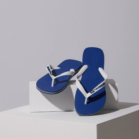 Kids' cobalt blue flip flop with white straps and Brazil flag detail, lifestyle image