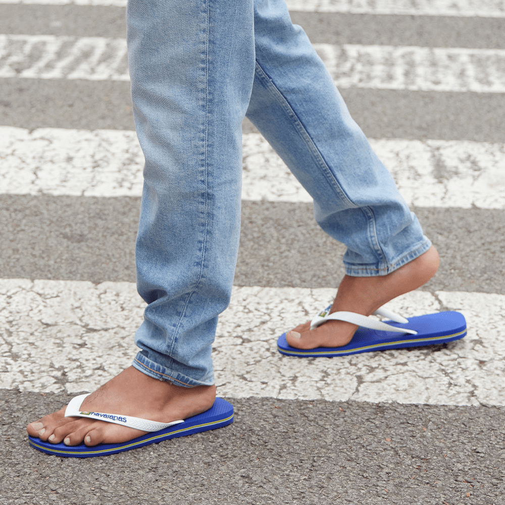 Kids' cobalt blue flip flop with white straps and Brazil flag detail, lifestyle image alternate