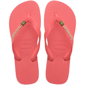 coral pink flip flops with pink straps that feature a small brazil flag, top view