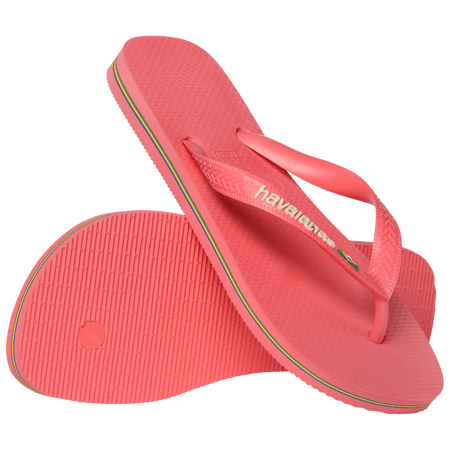 coral pink flip flops with pink straps that feature a small brazil flag, one shoe leaning on the other toe side down