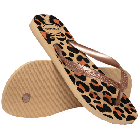 flip flops with black, brown, and beige leopard print and beige metallic straps, one shoe leaning on the other shoe toe side down