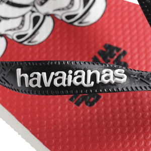 Flip flops with Star Wars' Darth Vader and drones on a red, grey, and white background with black straps, zoomed onto the white havaianas name on the black strap