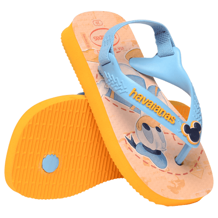 baby sandals with mickey mouse and donald duck on a yellow background with blue straps and a mickey mouse charm,one sandal toe side down leaning on the other sandal