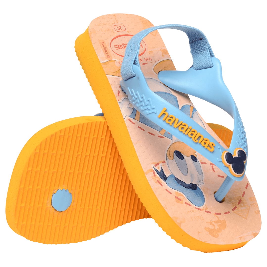 baby sandals with mickey mouse and donald duck on a yellow background with blue straps and a mickey mouse charm,one sandal toe side down leaning on the other sandal