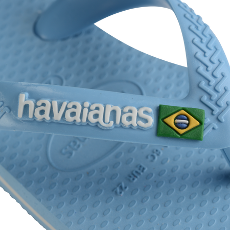 Blue baby flip flop, zoomed in on Havaianas logo and Brazilian flag on strap