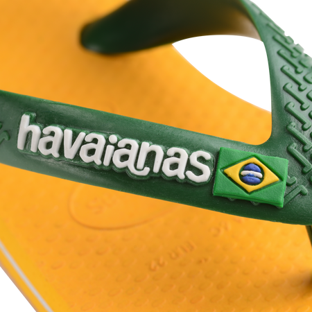 yellow flip flops with green heel straps featuring a brazil flag,zooming in on strap and white havaianas written on the strap with a brazil flag next to it