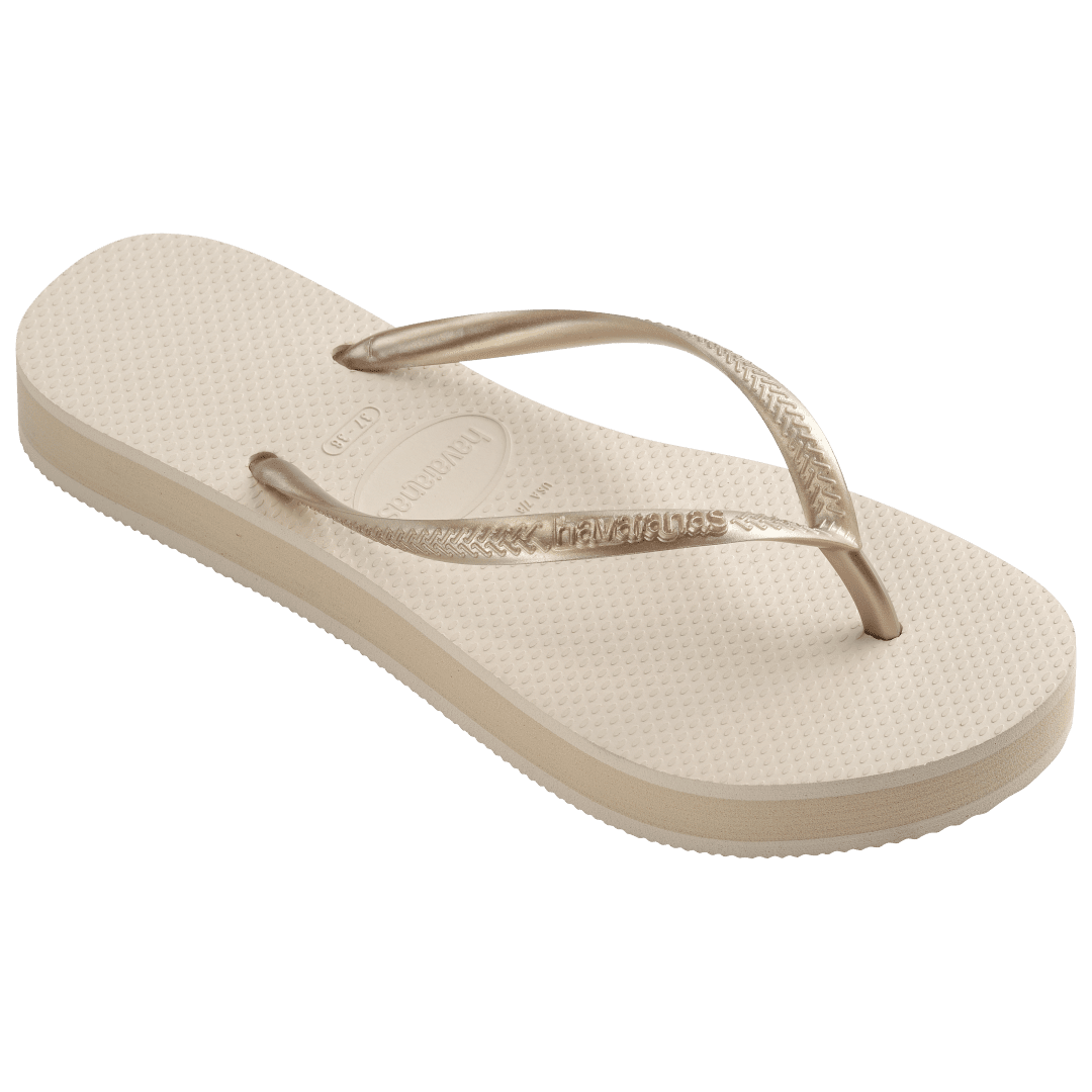 beige platform flip flop, with a darker beige colored midlayer between the sole and bottom of the flip flop, beige metallic straps, front right view