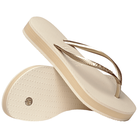 beige platform flip flop, with a darker beige colored midlayer between the sole and bottom of the flip flop, beige metallic straps, one sandal leaning on the other, toe side down