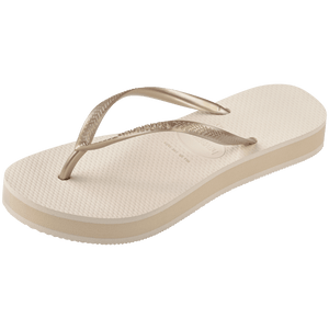 beige platform flip flop, with a darker beige colored midlayer between the sole and bottom of the flip flop, beige metallic straps, front left view