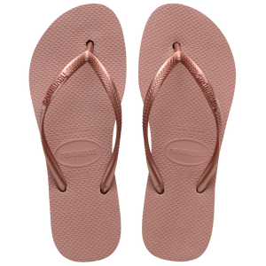 light pink flip flops with a platform and a pink metallic strap, one sandal balancing on the other, top view