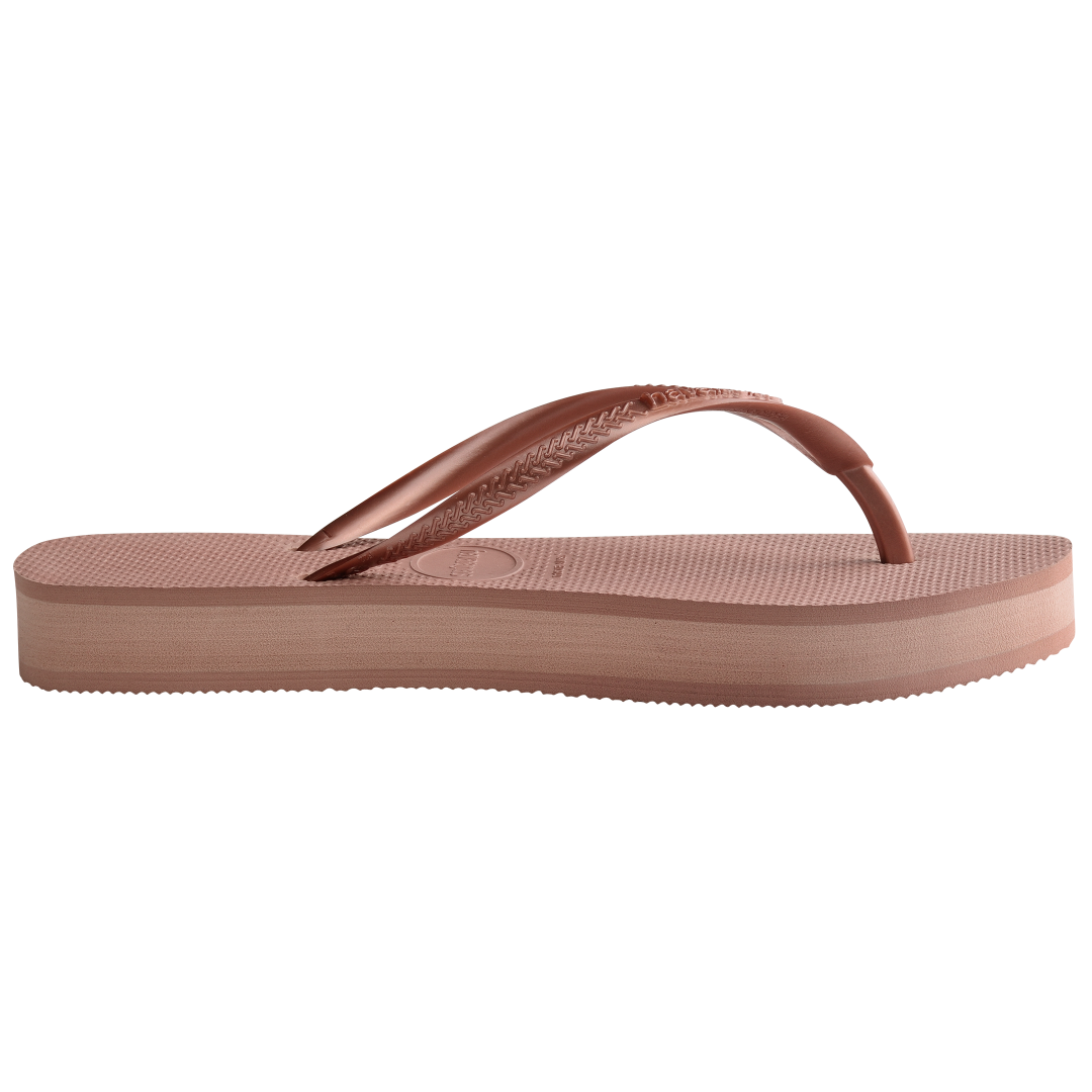 light pink flip flops with a platform and a pink metallic strap, side view, two toned pink layer between sole and bottom of shoe