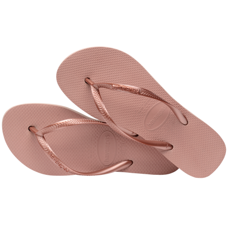 light pink flip flops with a platform and a pink metallic strap, one sandal lying on the other, top view, diagonal