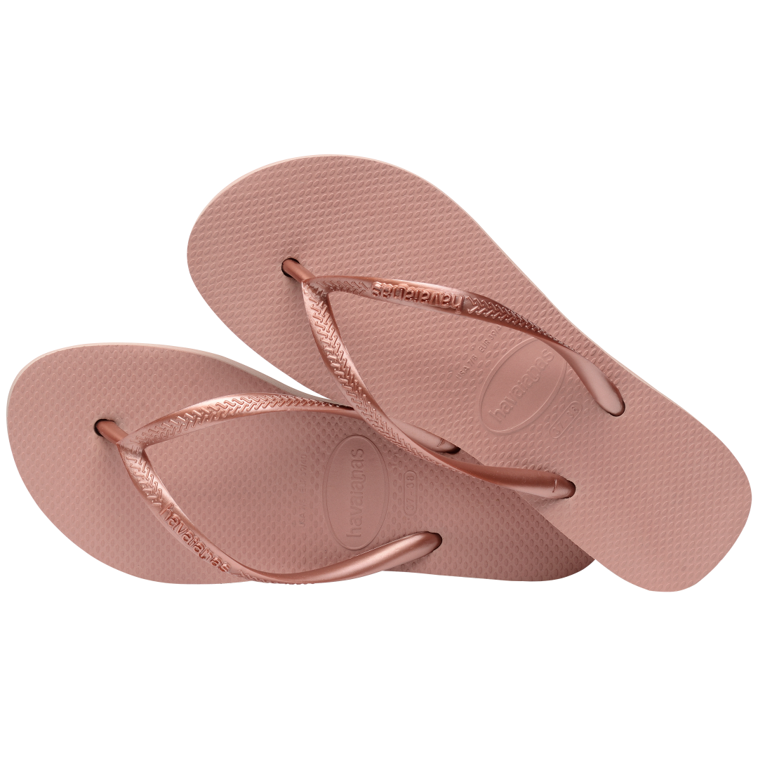 light pink flip flops with a platform and a pink metallic strap, one sandal lying on the other, top view, diagonal