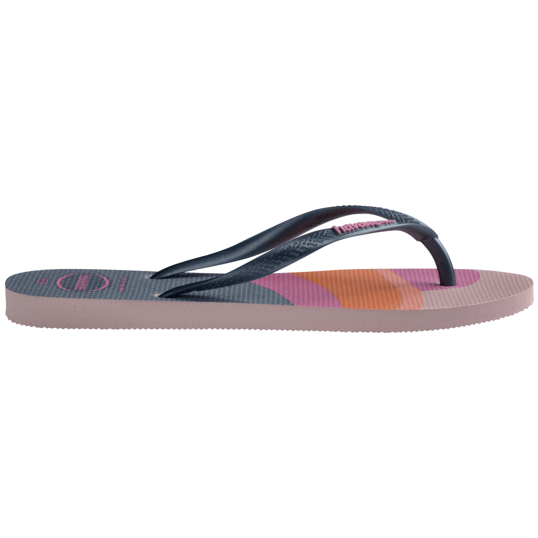 Kid's multicolor abstract print of sunset over the horizon of waves flip flops with navy glitter straps and pink logo side view