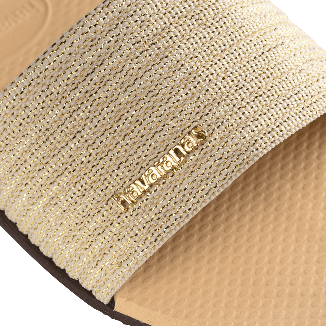 women's beige slide with tonal metallic upper gold logo detail view