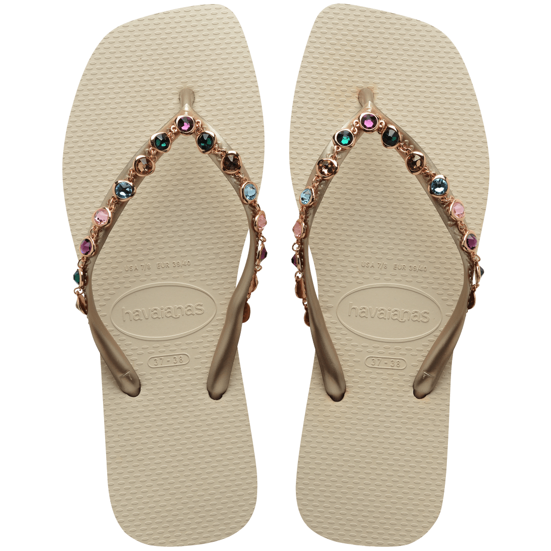 Women's square toe cream flip flops and gold straps with multicolor crystals, top view