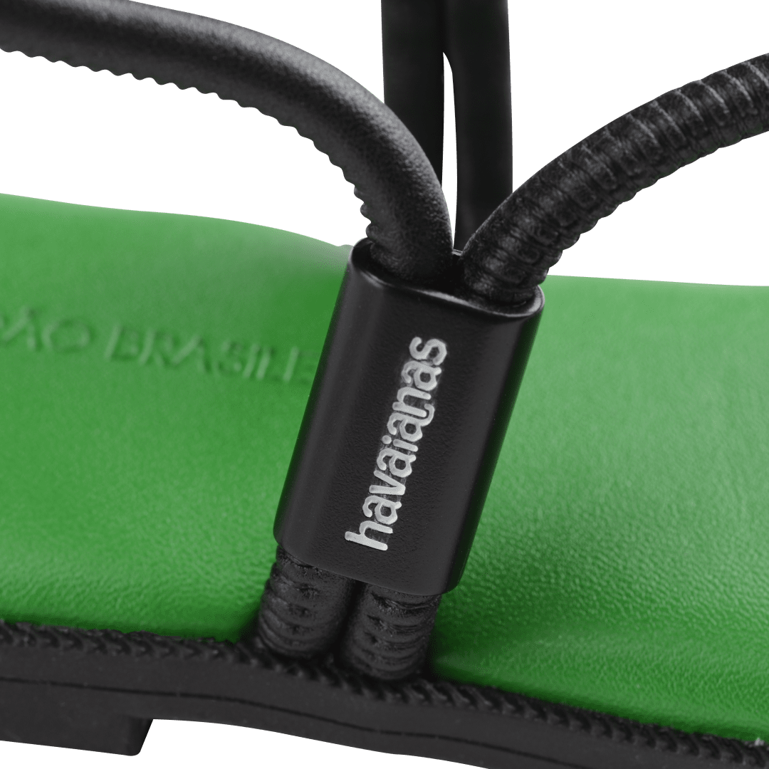 Women's green sole sandal with black straps logo detail view