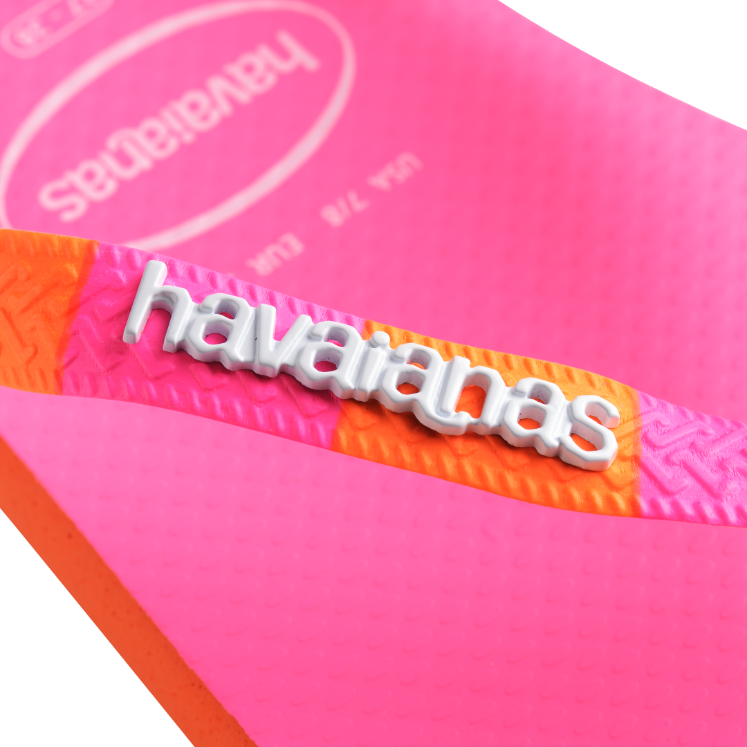 Women's neon pink flip flop with orange and pink striped straps logo detail