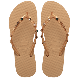 Women's tan flip flops with gold metallic straps featuring multicolor crystals top view