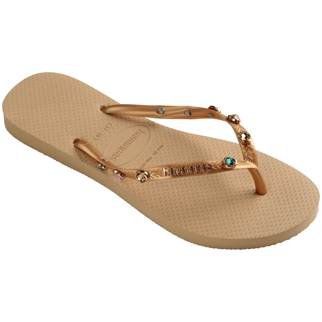 Women's tan flip flops with gold metallic straps featuring multicolor crystals right foot 3/4 view