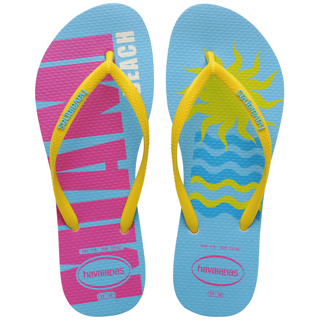 Women's light blue flip flops with yellow straps and pink Miami print on the left foot and yellow sun and blue waves print on the right foot top view