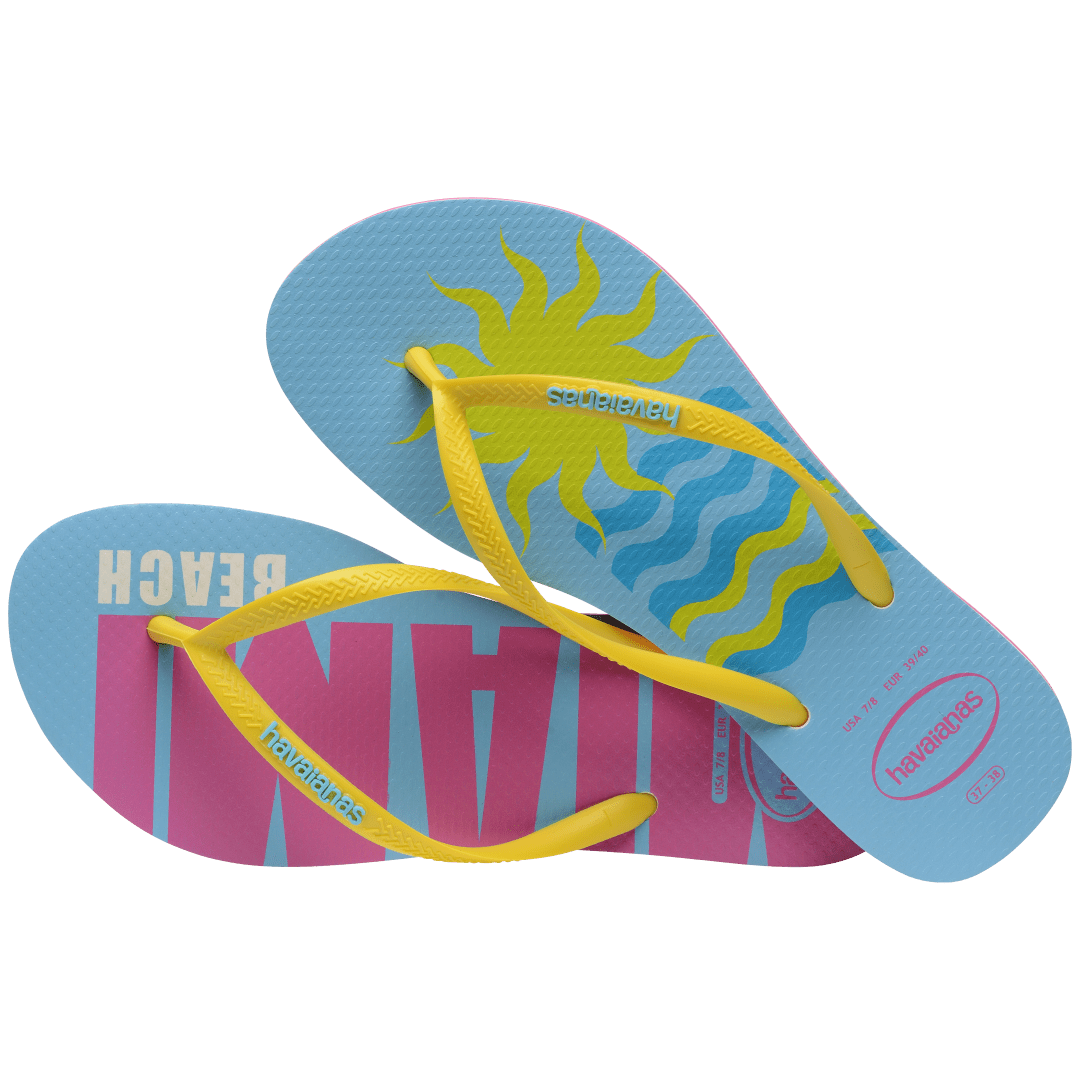 Women's light blue flip flops with yellow straps and pink Miami print on the left foot and yellow sun and blue waves print on the right foot alternate top view