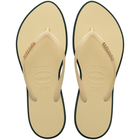 Women's cream pointed toe flip flops with dark green contrast sole top view