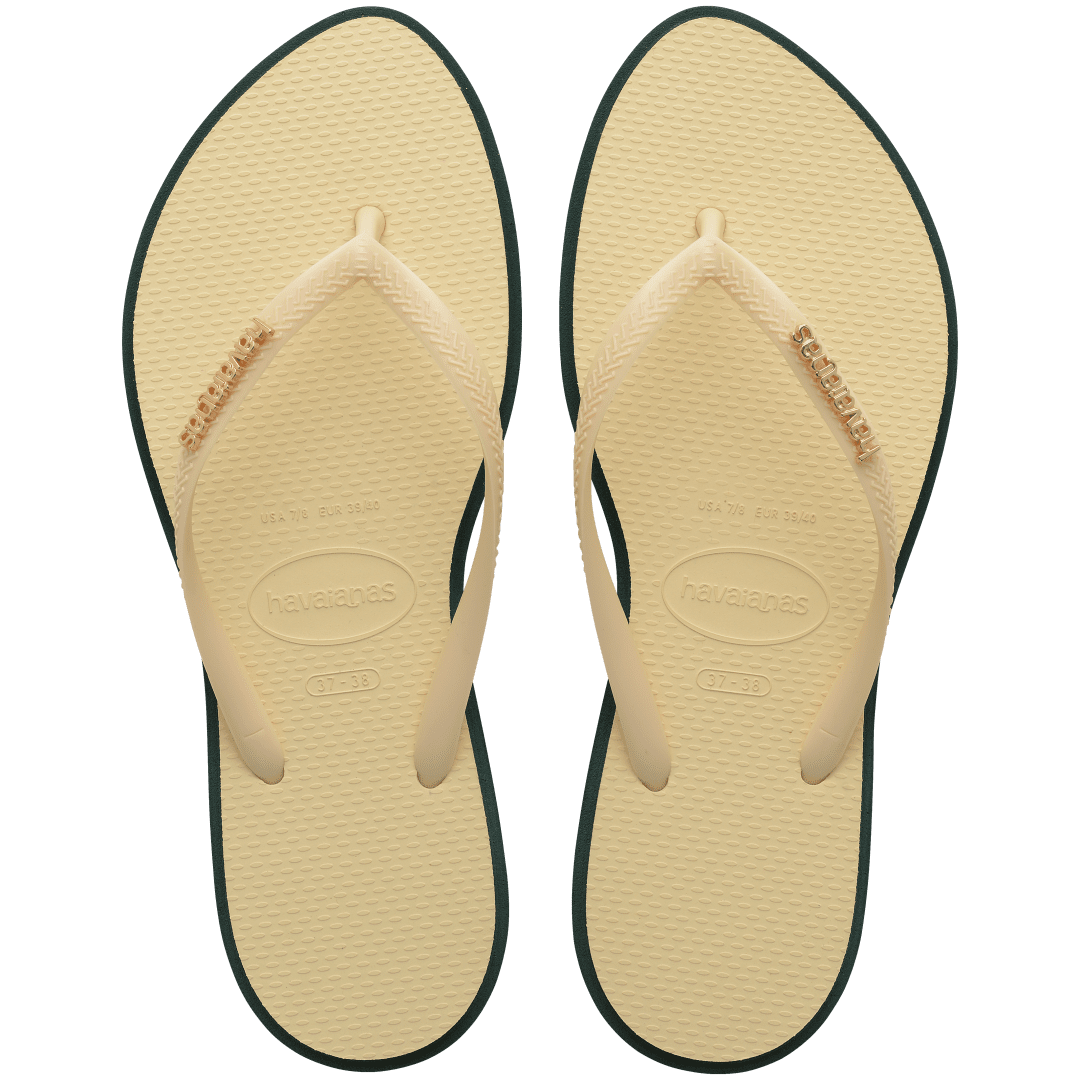 Women's cream pointed toe flip flops with dark green contrast sole top view