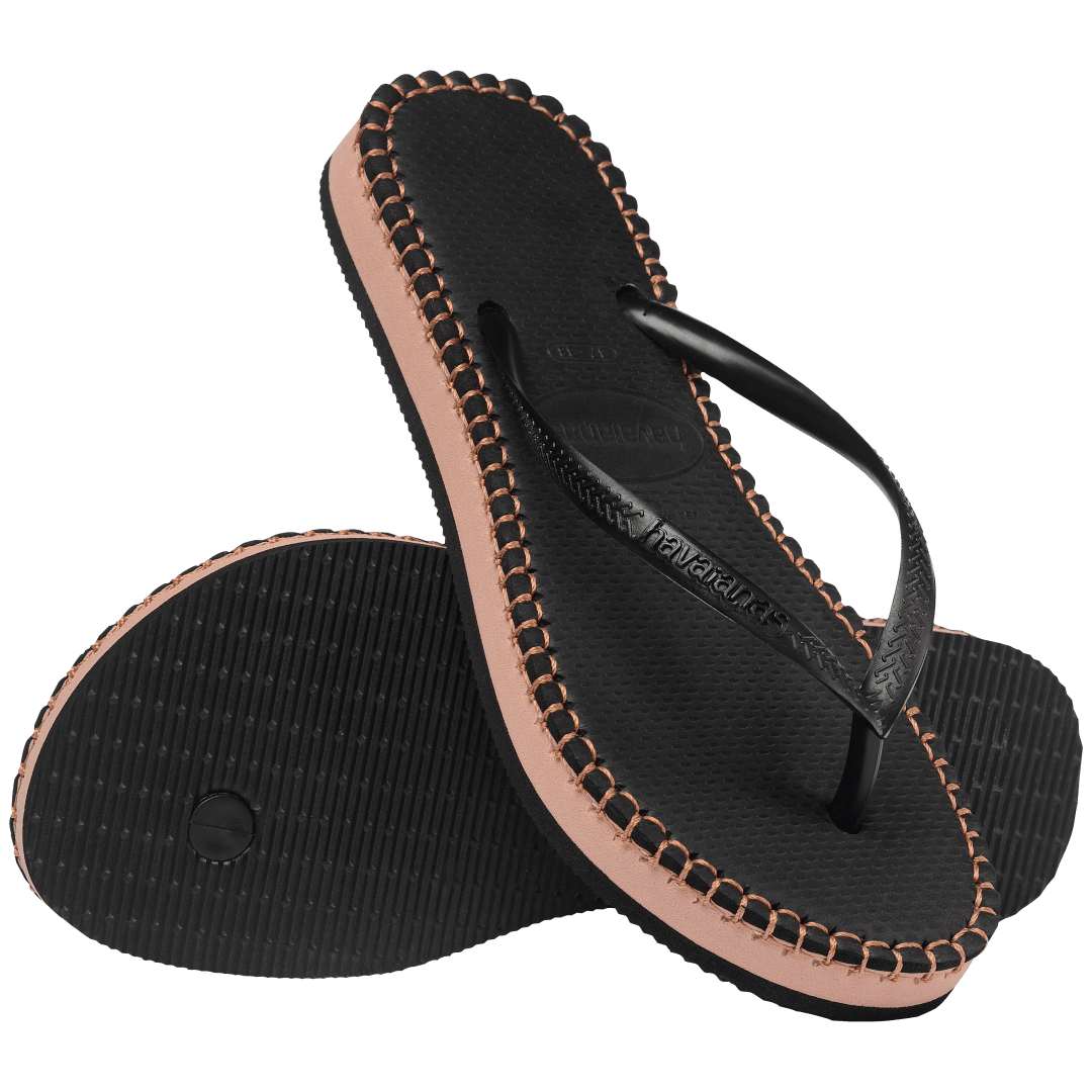 black flip flops with brown stitching, a brown midlayer between the sole and bottom of flip flop, and black straps, one sandal leaning on the other sandal, toe side down