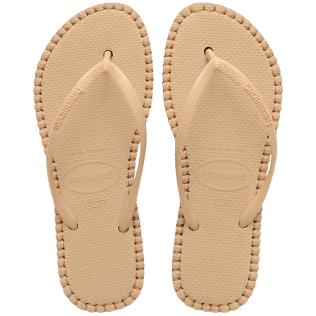 beige sandal with darker brown stitching and a dark brown midlayer between the sole and bottom of shoe, top view