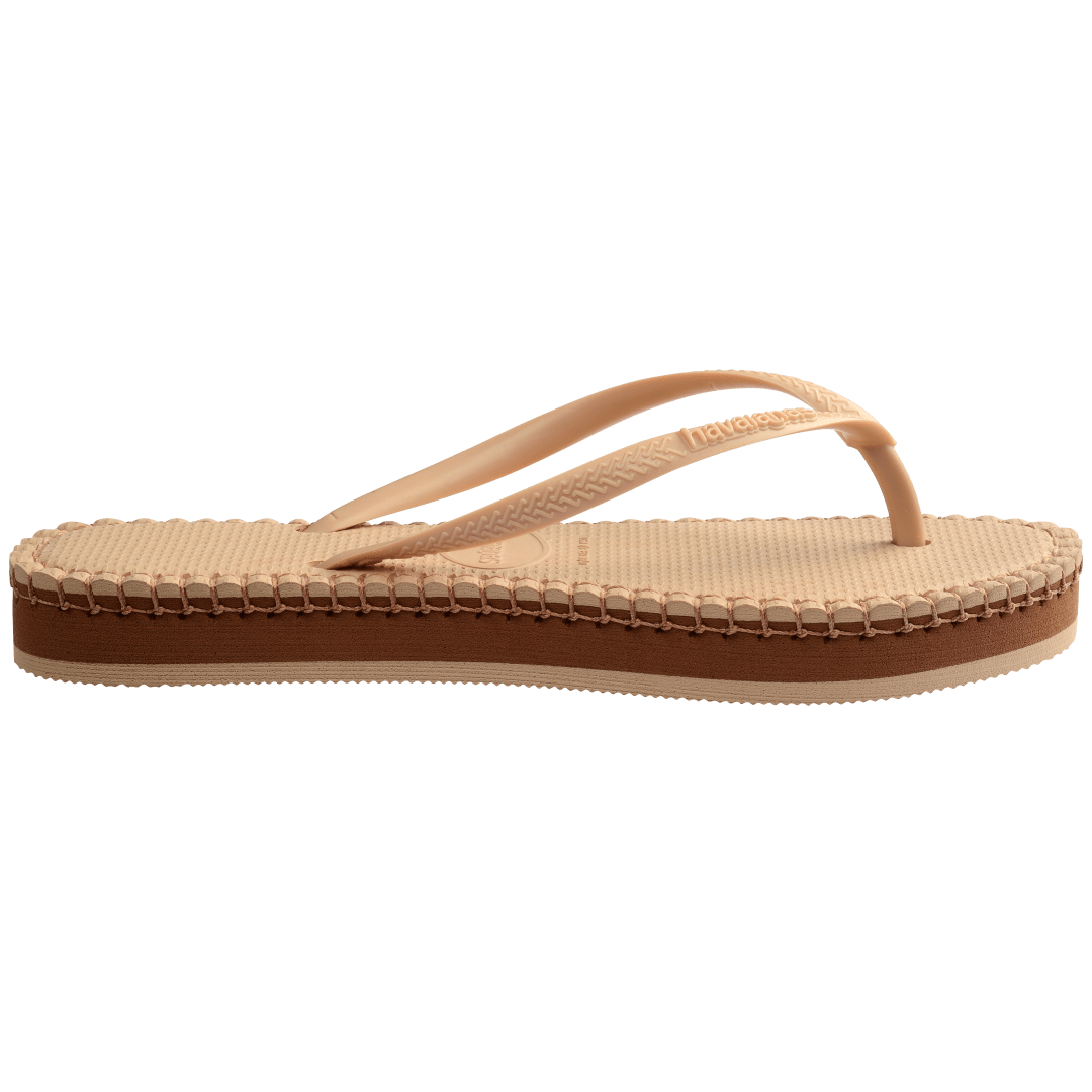 beige sandal with darker brown stitching and a dark brown midlayer between the sole and bottom of shoe, side view