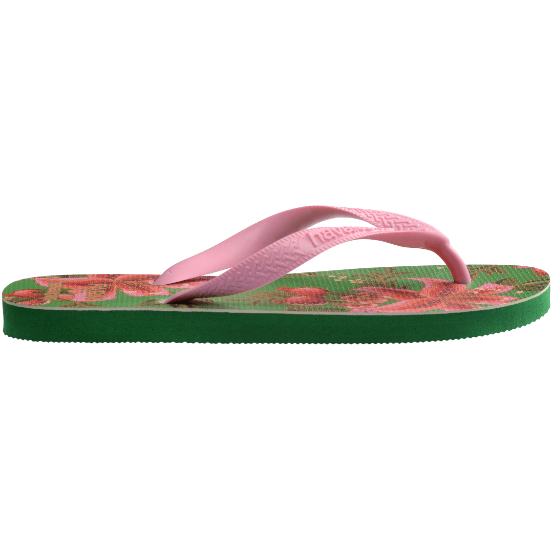 flip flops with green sole featuring pink flowers and pink straps, side facing