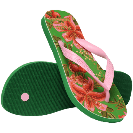 flip flops with green sole featuring pink flowers and pink straps, one flip flop resting on the other on diaganol