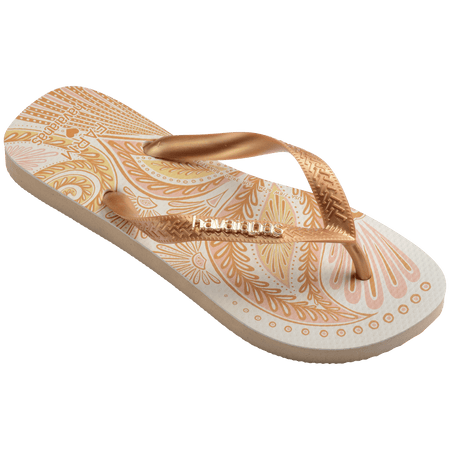 flip flops with gold and light pink abstract print and metallic gold straps with a metal havaianas logo, front, diagonal side facing