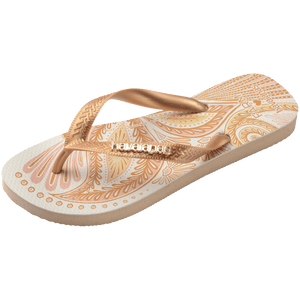 flip flops with gold and light pink abstract print and metallic gold straps with a metal havaianas logo, front, diagonal facing