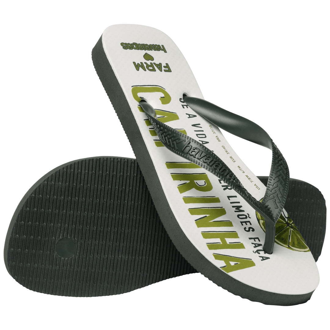 flip flops with a drink with green lime and ice in it on a white background with olive green straps, one flip flop resting on it's toe, top facing, on the other flip flop