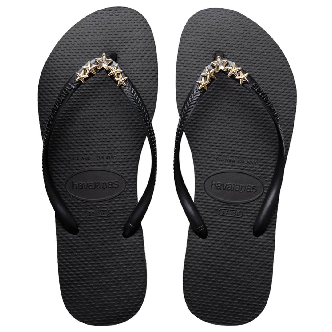 Women's black flip flops with gold star charm embellishment, top view